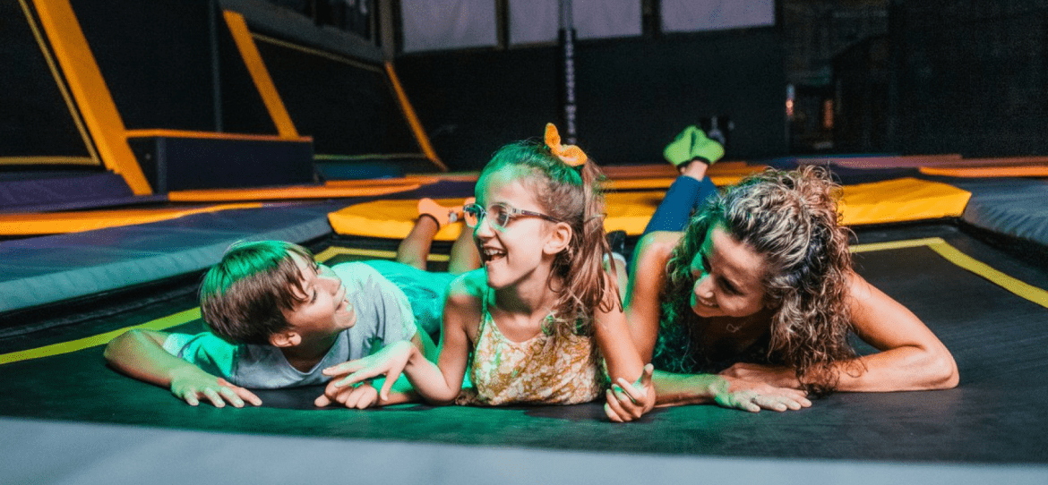 Three children laying on trampoline